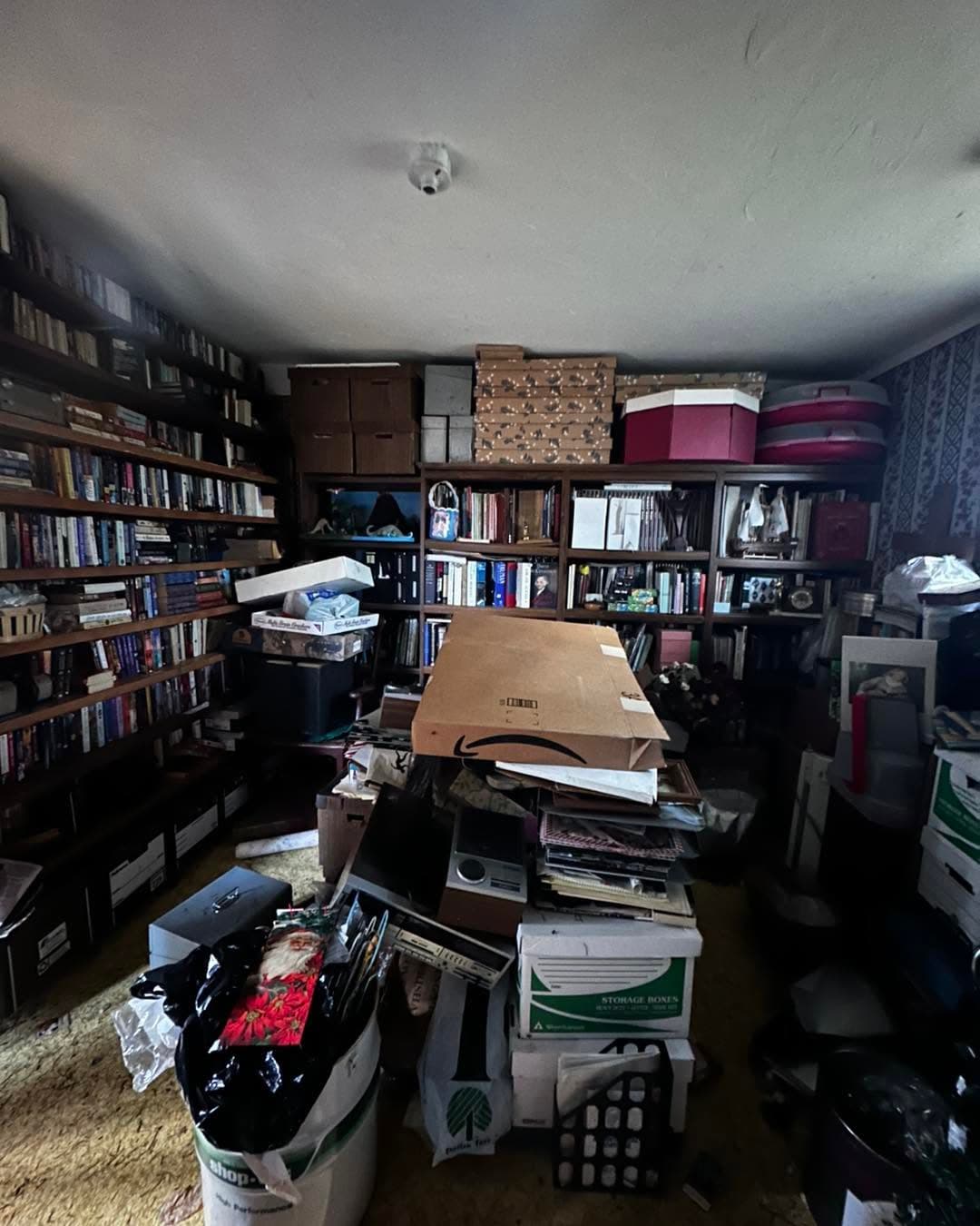 Cluttered home office with overflowing shelves and boxes, highlighting disorganization.
